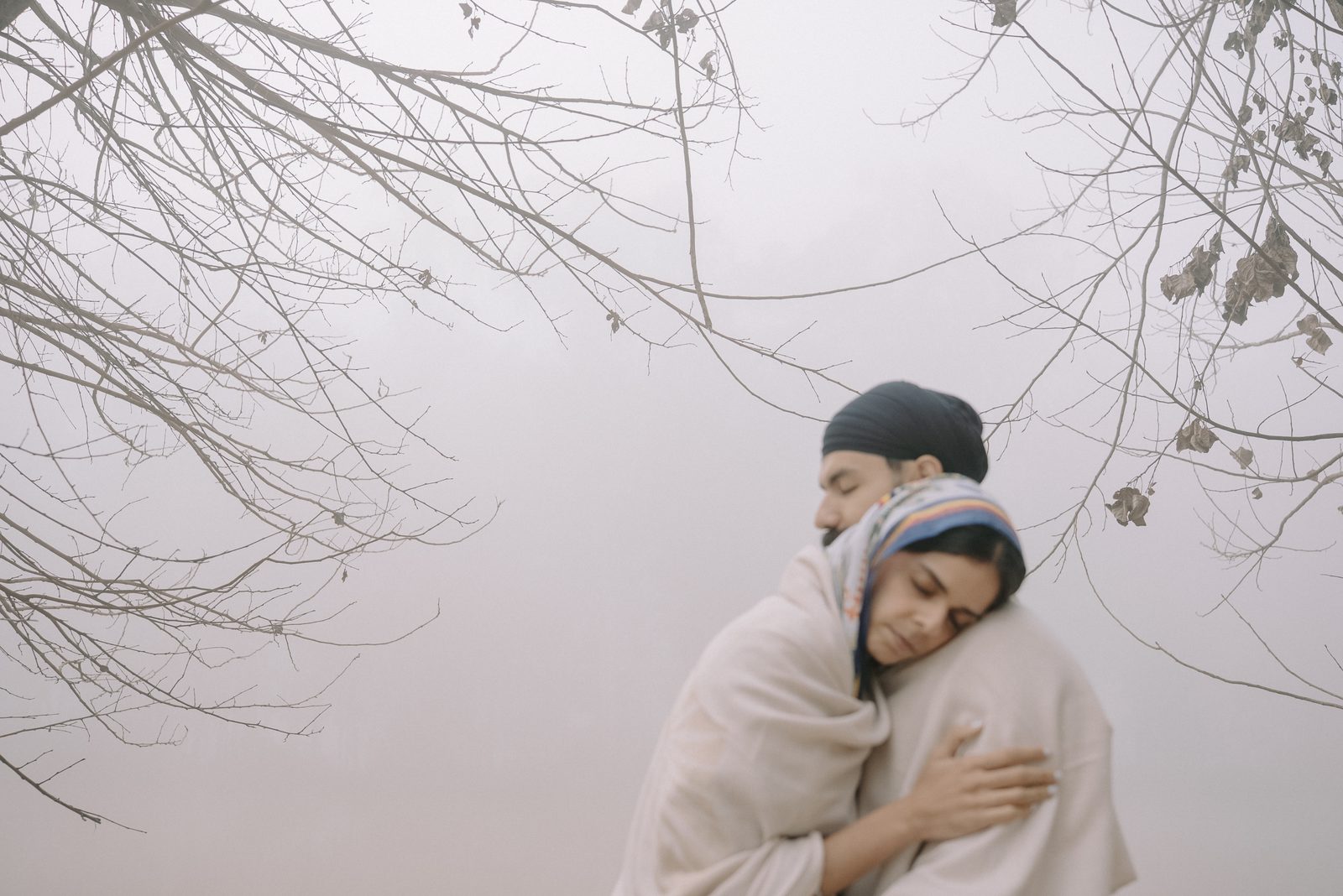 Naaz and Himmat wrapped in a shawl in the winter fog, film still