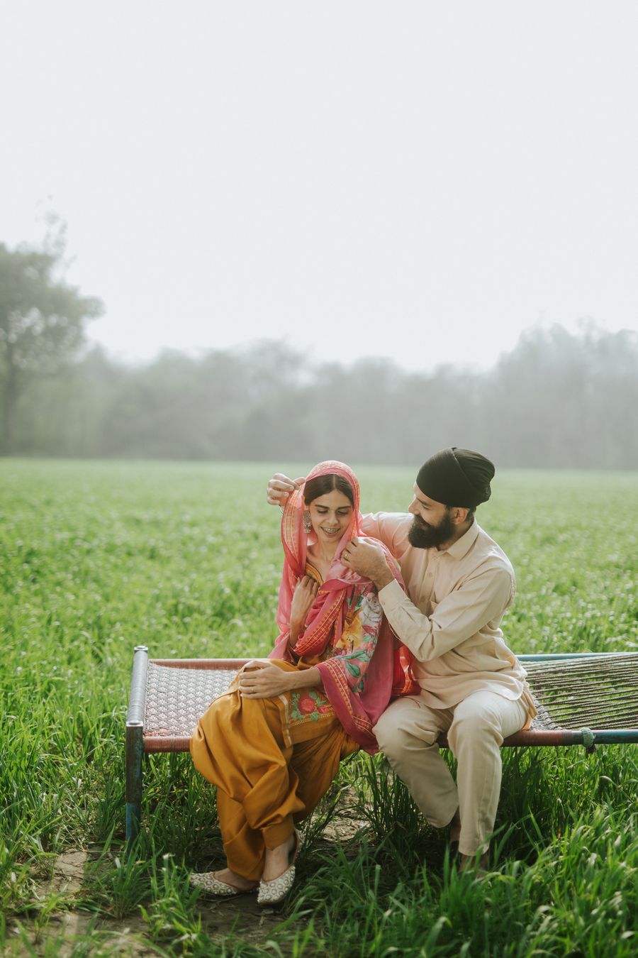 Himmat draping the dupatta over Naaz on the charpai