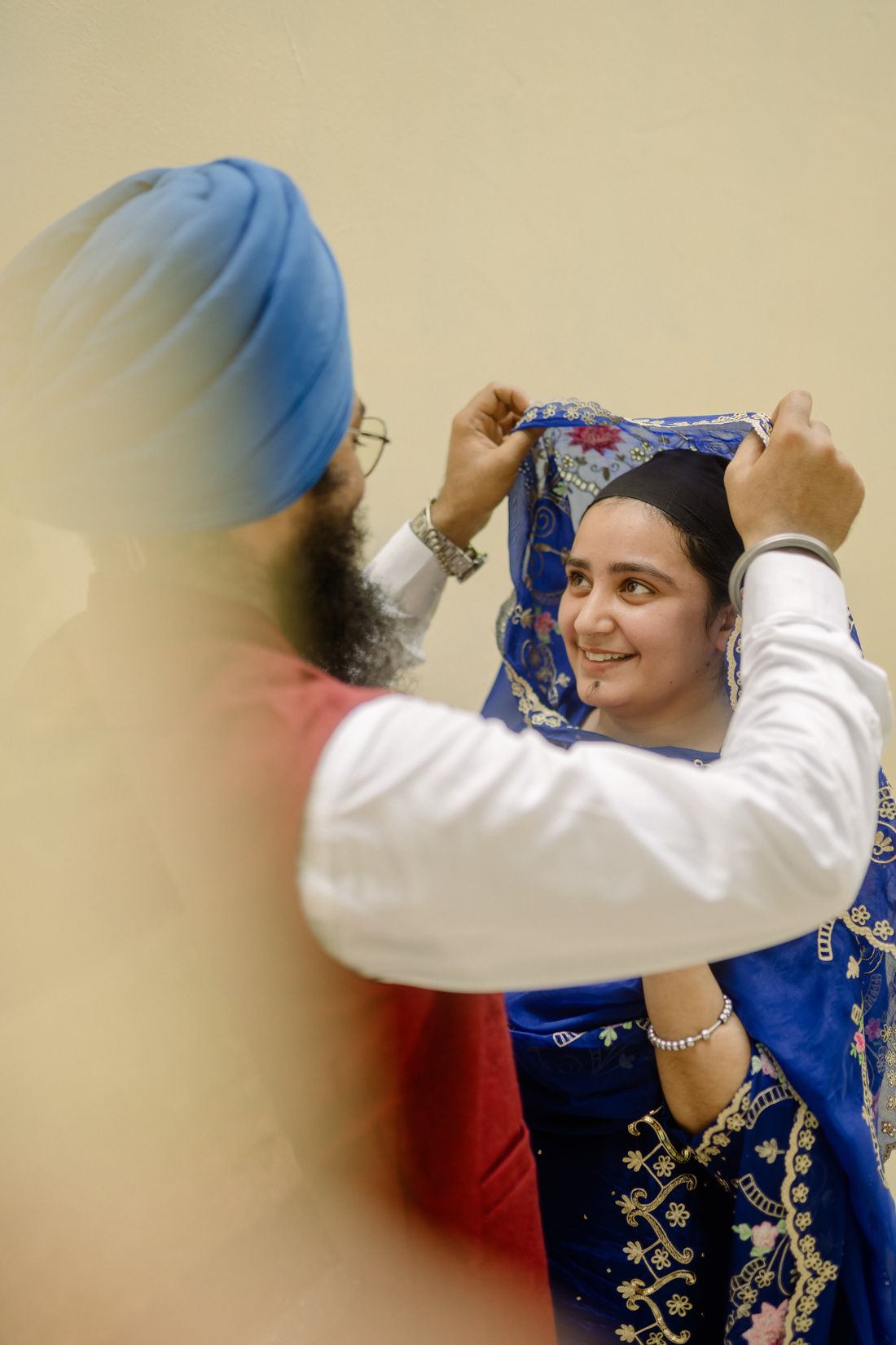Naaz smiling as the embroidered dupatta settles over her head